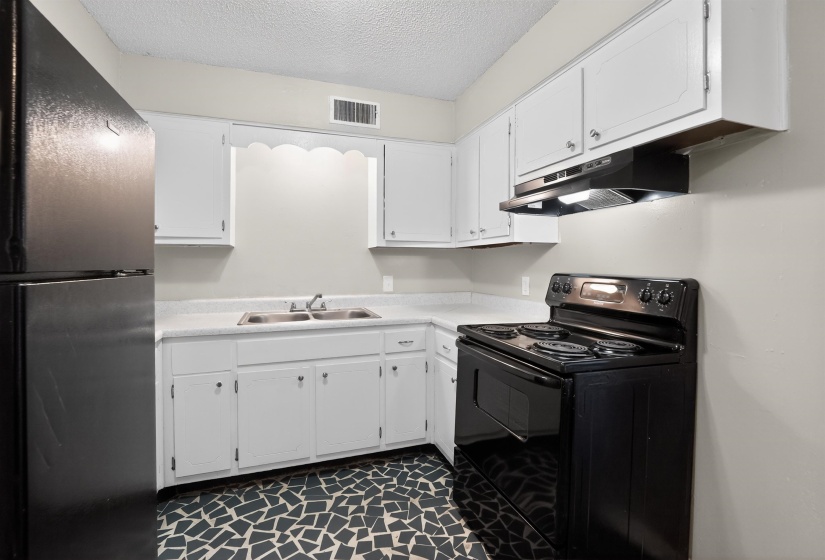 Kitchen featuring white cabinetry and countertops