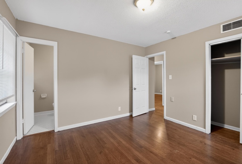 Expansive room featuring wood-finish flooring, neutral wall tones, and white trim
