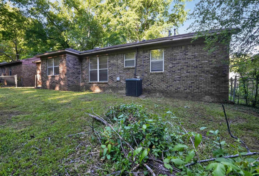Brick exterior with multiple windows and an HVAC unit