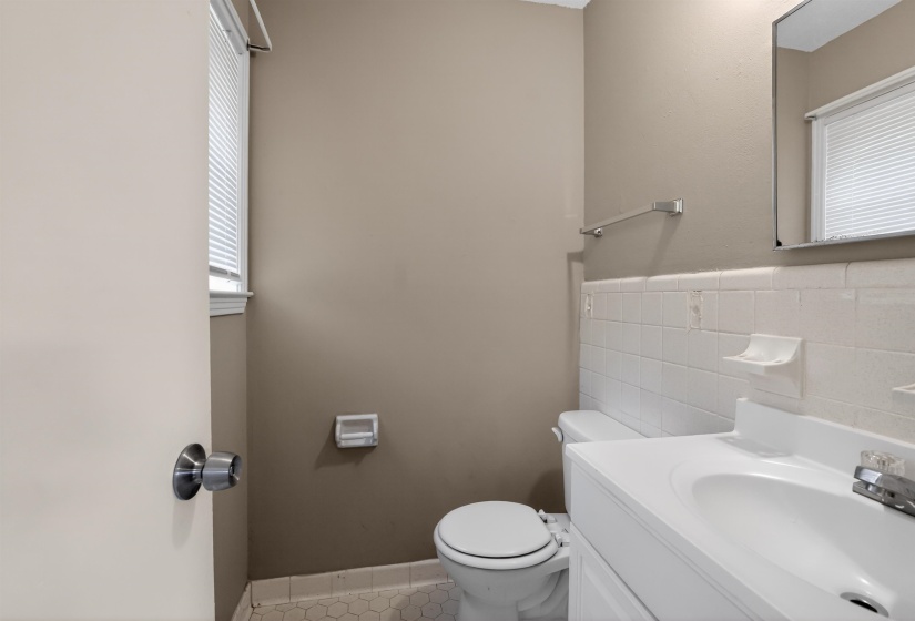 Bathroom featuring a white vanity with integrated sink, chrome faucet, and mirrored medicine cabinet