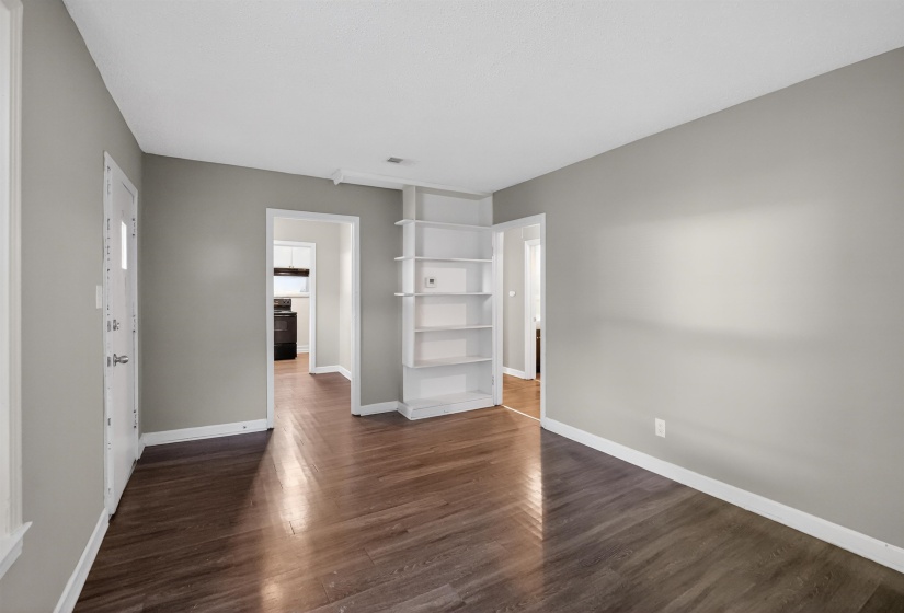 Spacious interior with dark wood-finish flooring and light gray walls