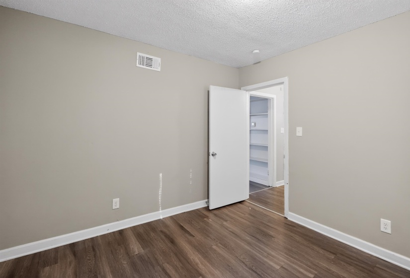 Room featuring wood-finish flooring, light neutral wall paint, and white trim