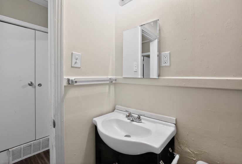Pedestal sink with chrome fixtures and medicine cabinet with mirrored front