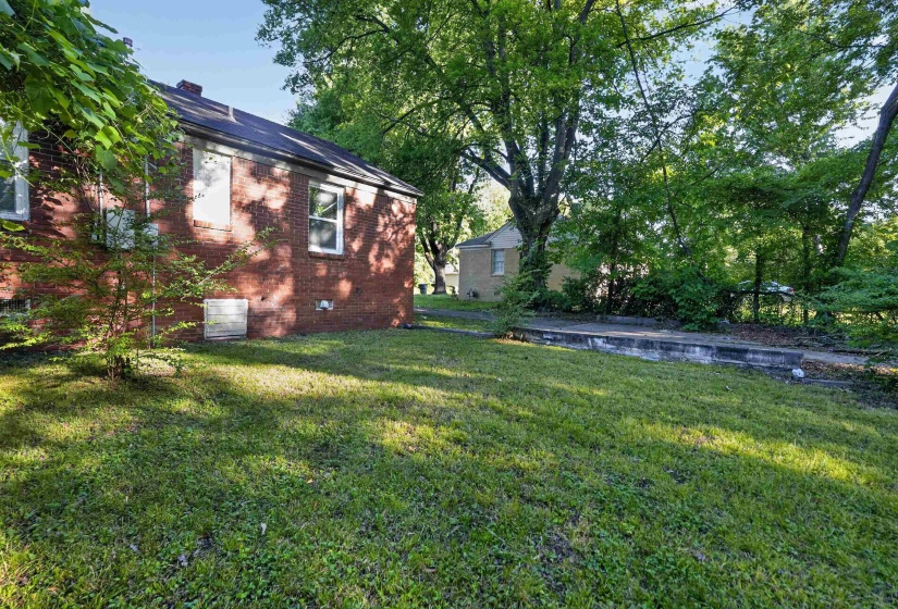 Brick exterior residence with a dark shingle roof and multiple windows