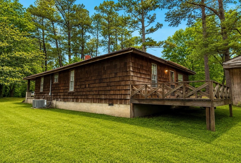 Wood-shingle exterior featuring a raised wooden deck with a geometric railing design