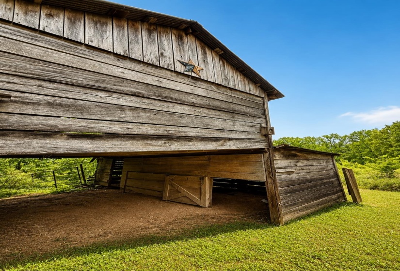 Rustic barn structure featuring natural wood siding and a corrugated metal roofline