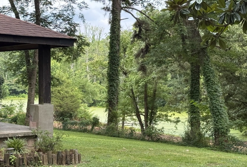 Covered outdoor structure featuring a brown shingle roof and substantial support posts