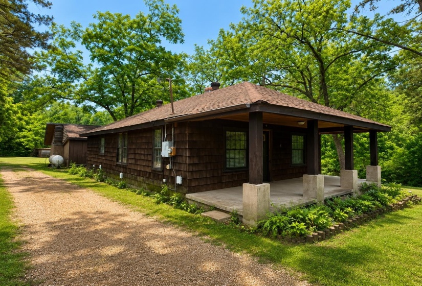 Shingle-sided residence featuring a covered front porch with concrete pillars