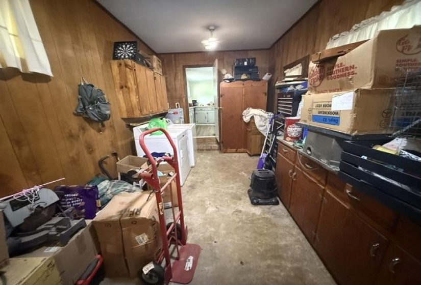 Wood-paneled room featuring built-in cabinetry, a utility sink, and a visible doorway