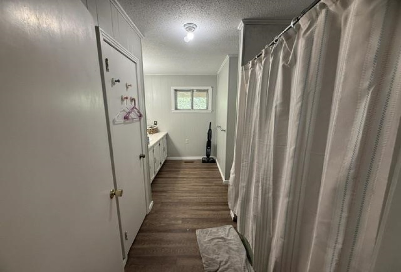 Interior space with wood-finish flooring, white paneled walls, and a window