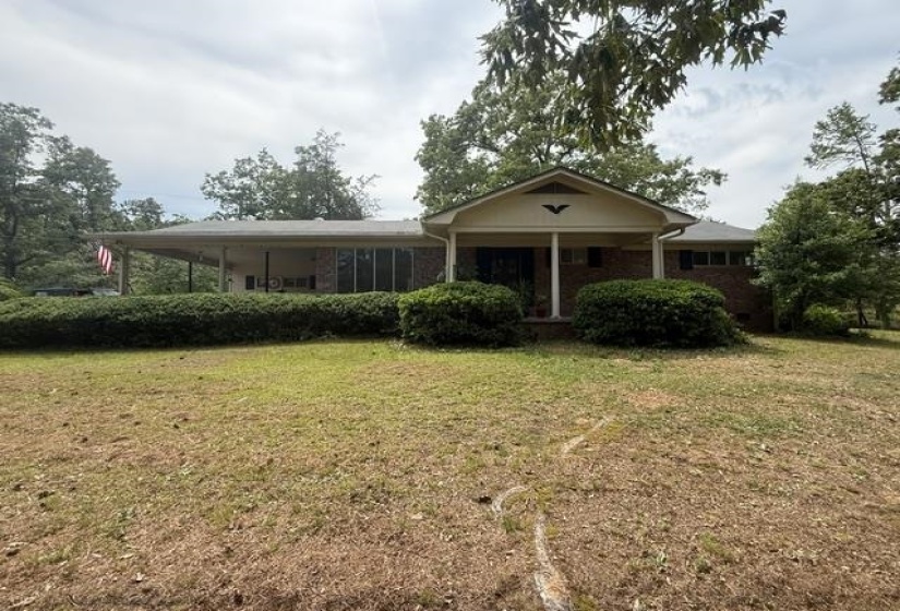 Brick exterior with a covered front porch and an extended side carport