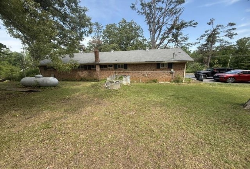 Brick exterior with multiple windows and a shingled roof