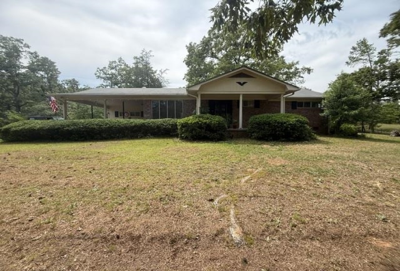 Brick ranch-style exterior featuring a covered front porch with white columns