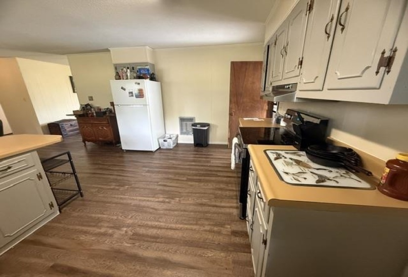 Kitchen featuring wood-finish flooring, light-toned cabinetry, a built-in range, a built-in refrigerator, and an island with a wood-finish countertop