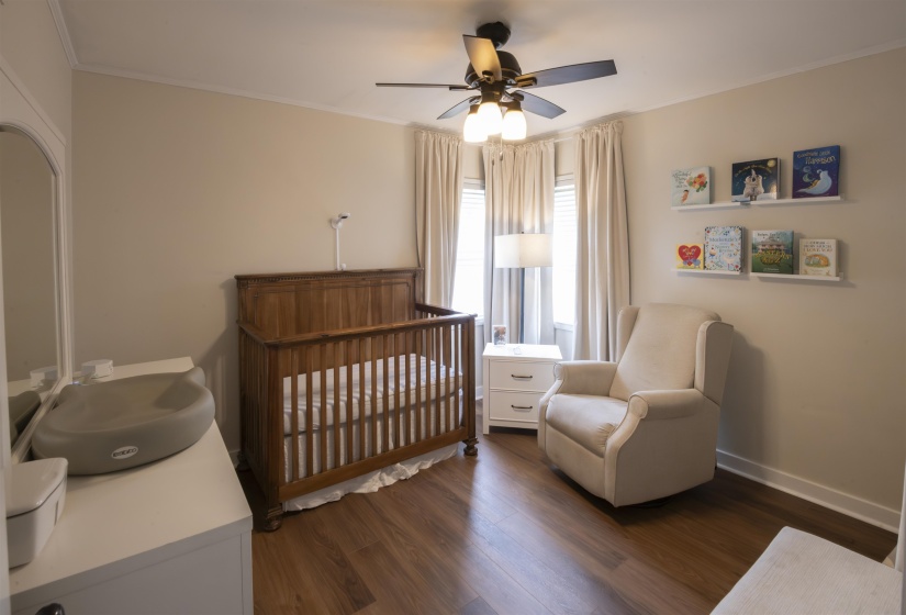 Interior room featuring wood-finish flooring, light neutral wall paint, and white trim molding