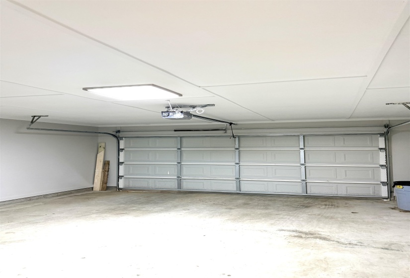 Concrete garage floor with white walls and ceiling paneling
