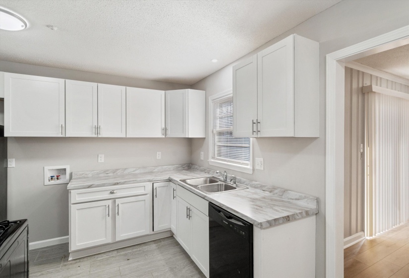 Kitchen with light countertops, black dishwasher, white cabinets, a textured ceiling, and gas range oven