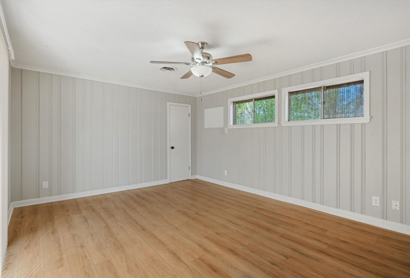 Spare room with light wood-style flooring, a ceiling fan, and ornamental molding