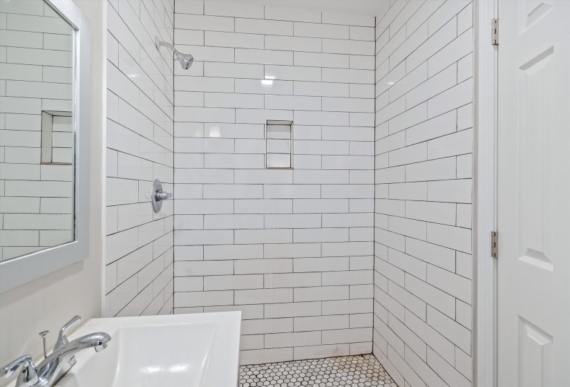 Full bathroom with a tile shower and a sink