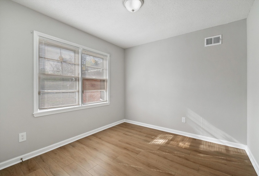 Empty room with wood finished floors and a textured ceiling