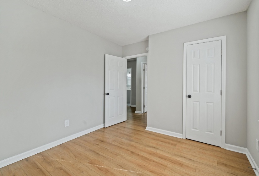 Unfurnished bedroom with light wood finished floors and baseboards