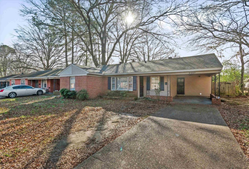 Ranch-style home with an attached carport, driveway, brick siding, a porch, and a shingled roof