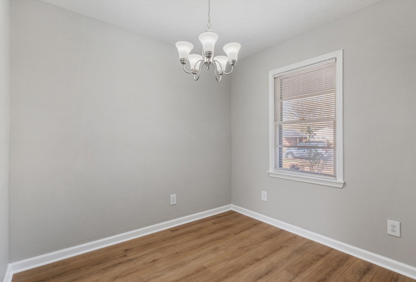 Unfurnished room with wood finished floors and a chandelier