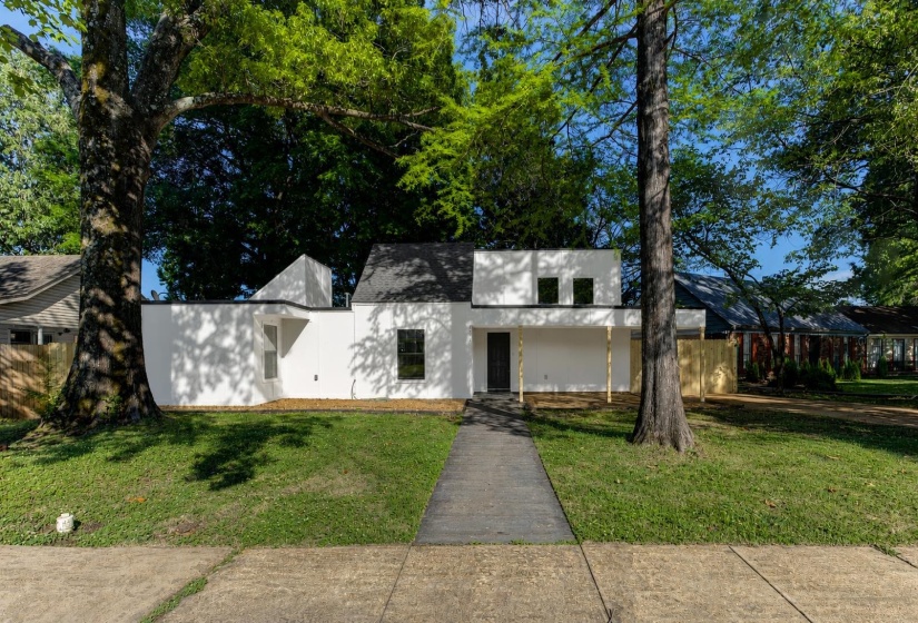 Modern exterior featuring a prominent black entry door, dark-framed windows, and a black shingle roof