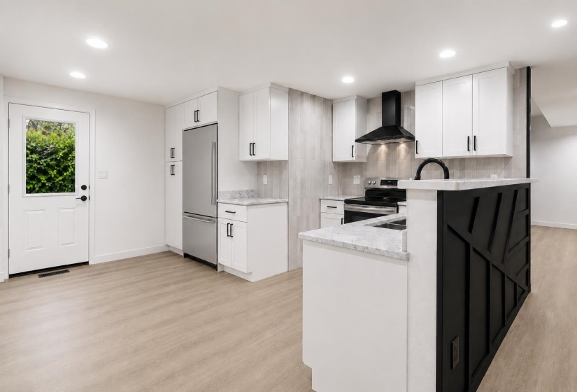 Modern kitchen featuring white cabinetry, light wood-finish flooring, stainless steel appliances, and a black decorative island accent