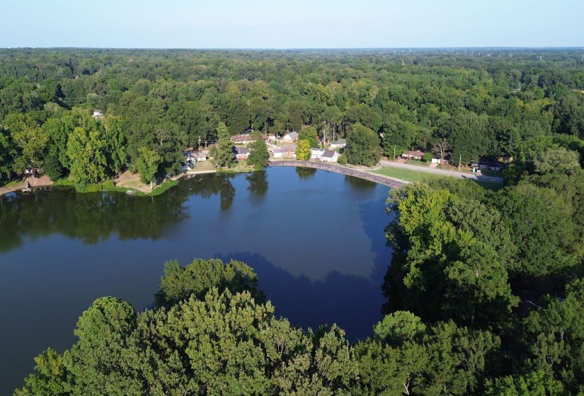 Aerial view of property's location featuring a heavily wooded area and a large body of water