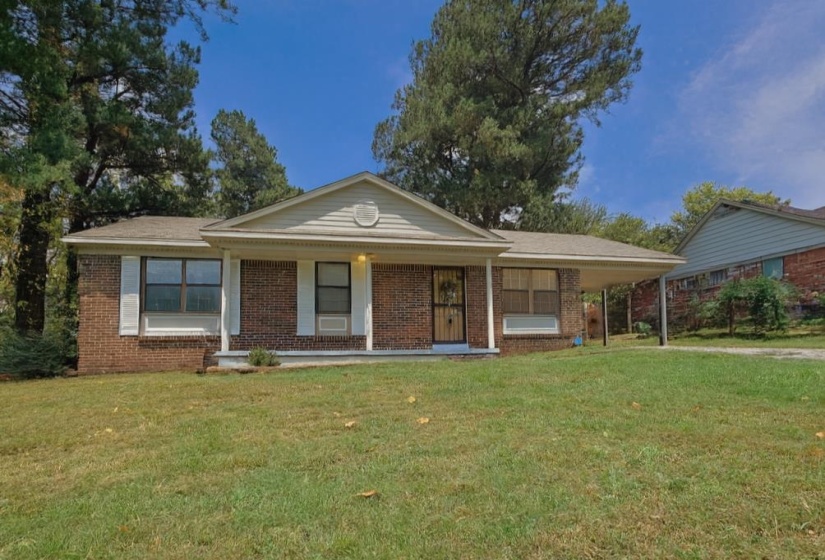 Ranch-style house with covered porch, brick siding, and a front yard