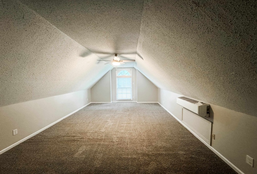 Additional living space with ceiling fan, vaulted ceiling, a textured ceiling, and carpet