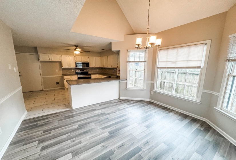 Kitchen featuring kitchen peninsula, stainless steel appliances, wood-type flooring, and tasteful backsplash