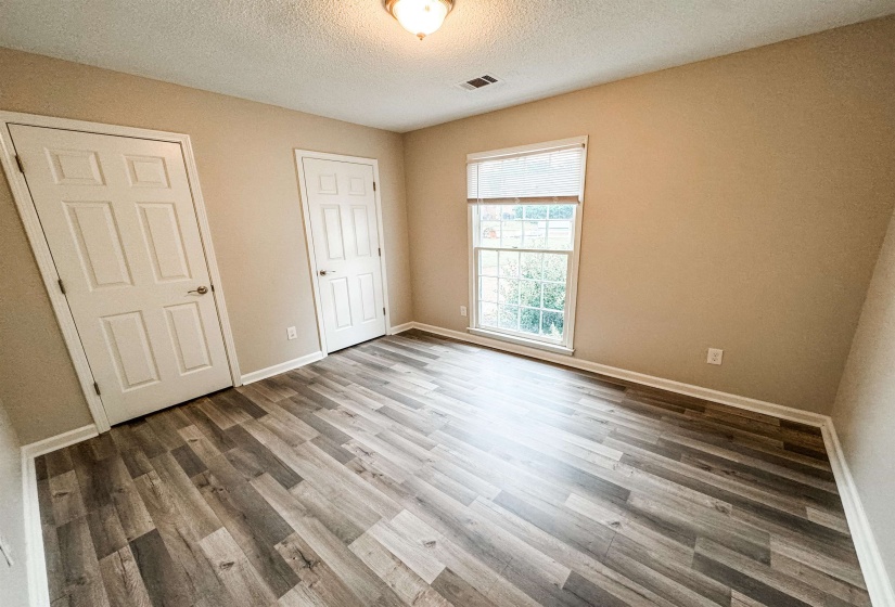 Unfurnished bedroom featuring a textured ceiling and hardwood / wood-style flooring
