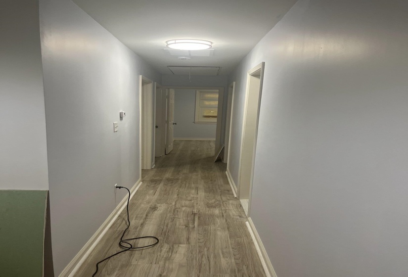 Hallway featuring attic access and light wood finished floors