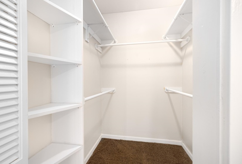 Walk in closet featuring dark colored carpet