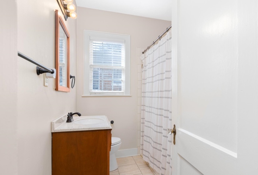 Bathroom with vanity, a shower with shower curtain, and light tile patterned floors