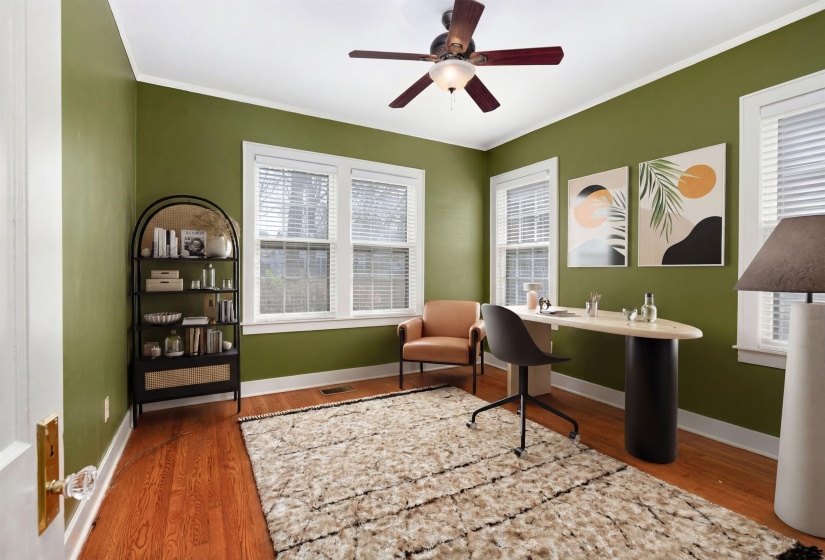 Office space with wood finished floors, ornamental molding, and a ceiling fan