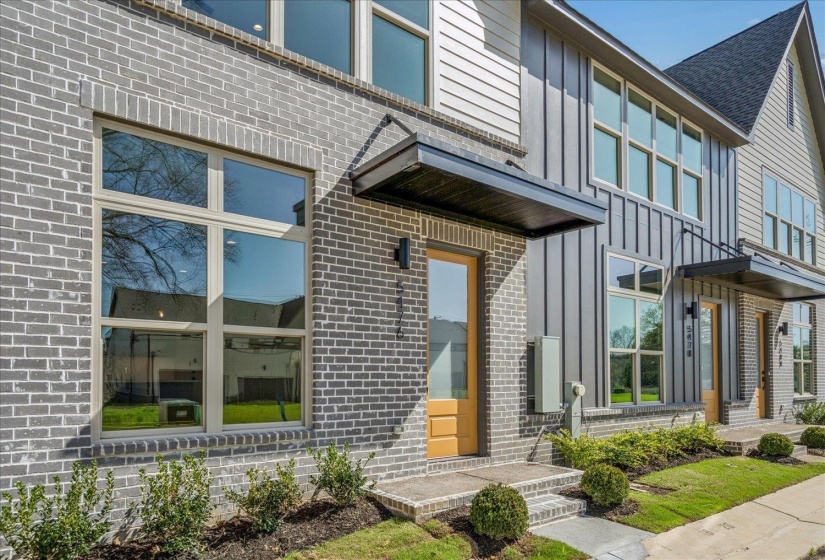 Doorway to property with board and batten siding and brick siding