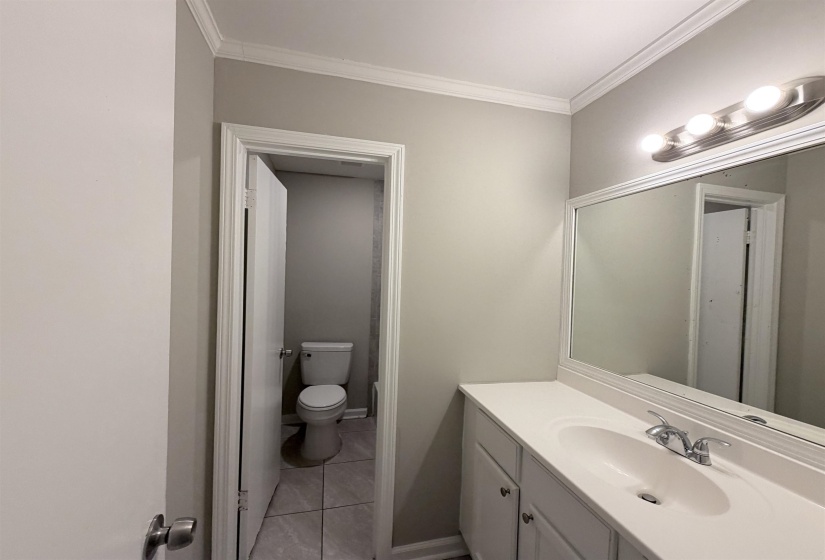 Bathroom vanity featuring an integrated sink, brushed nickel faucet, and a large mirror with a decorative frame