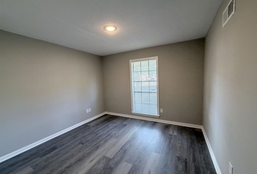 Room featuring wood-finish flooring, neutral wall paint, and white trim