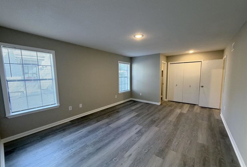 Spacious room featuring wood-finish flooring, neutral-toned walls, and recessed lighting