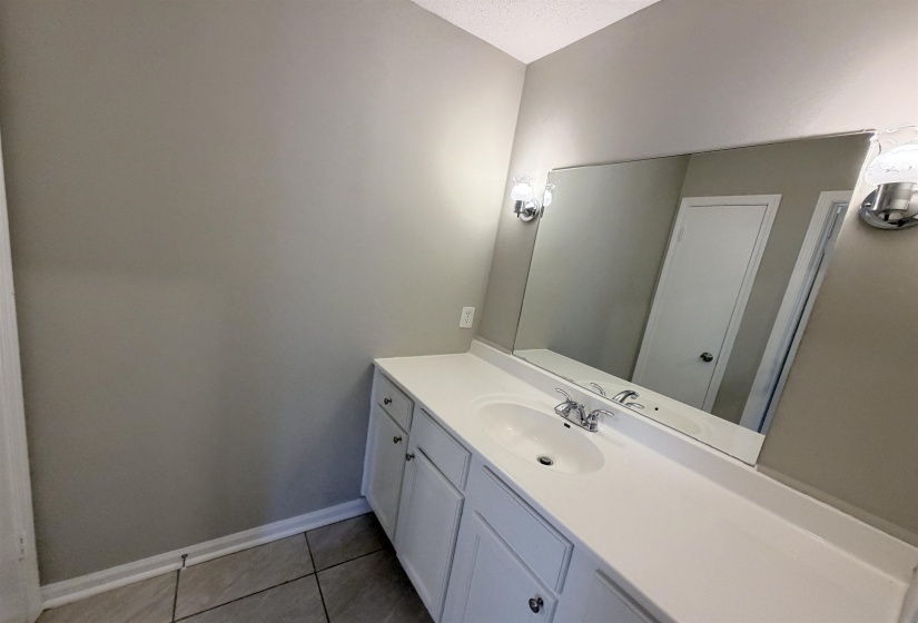 Bathroom vanity featuring a single basin, integrated countertop, and storage cabinetry