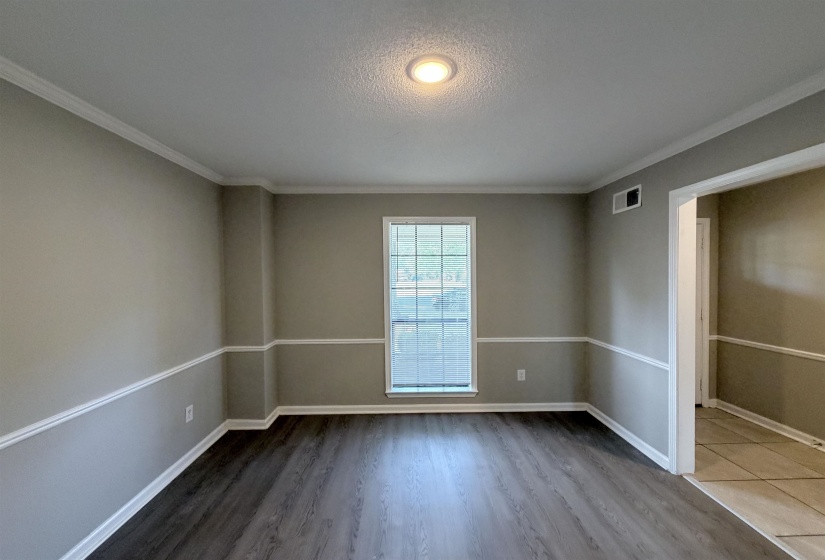 Spacious room featuring wood-finish flooring, a double window with white trim, and a recessed ceiling light
