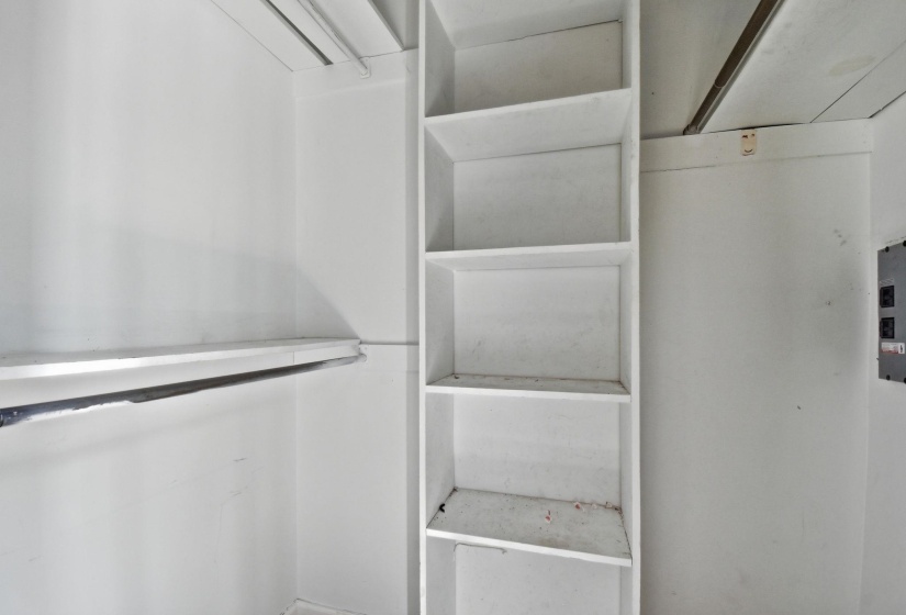 Built-in shelving unit with multiple storage compartments and an integrated hanging rod