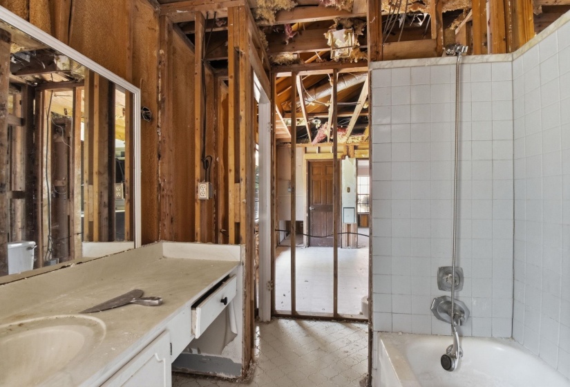 Bathroom featuring a built-in vanity with integrated sink, rectangular mirror, and a tiled shower-over-tub combination