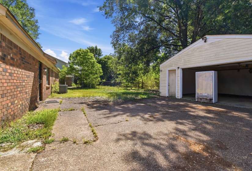 Detached garage structure with a side entry door and open bays