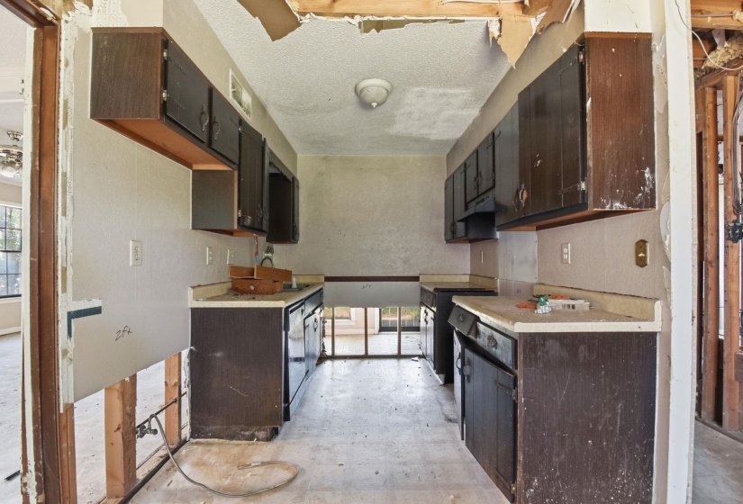 Kitchen featuring dark wood-finish cabinetry, light-toned countertops, and a ceiling-mounted light fixture