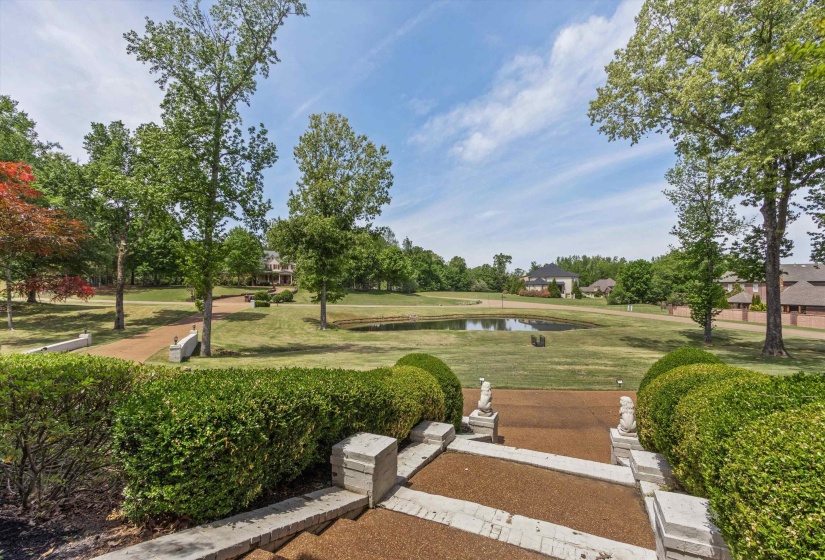 Front Porch View overlooking scenic pond, expansive lawn, and mature trees—offering a peaceful, picturesque setting.