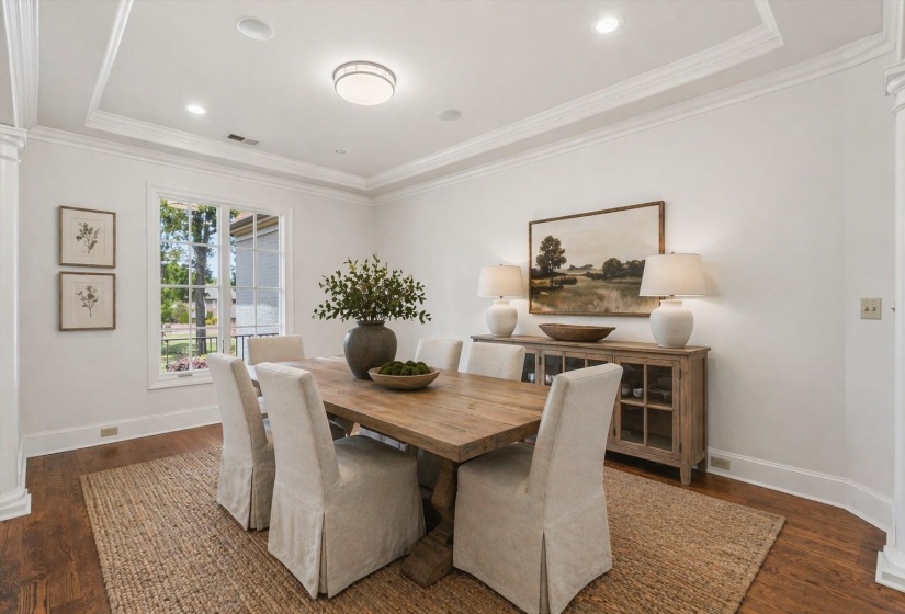 Beautifully styled with warm hardwood floors, crown molding, and soft natural light. A clean, inviting aesthetic perfect for everyday dining and entertaining. Virtually staged photo.